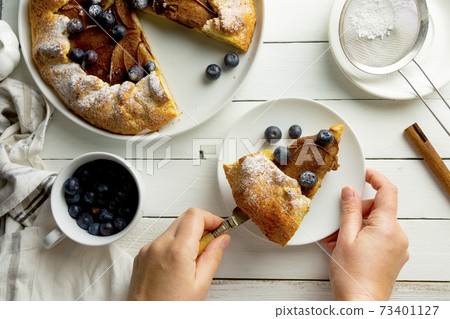 Galette or pie, tart with pears and cinnamon filling. Top view, white wooden background. 73401127