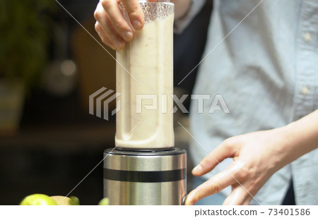 Female hands cooking almond milk Female hands cooking almond milk 73401586