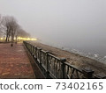 Deserted winter embankment in the fog 73402165