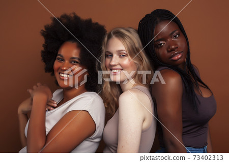 young pretty caucasian, afro, scandinavian woman posing cheerful together on brown background, lifestyle diverse nationality people concept young pretty caucasian, afro, scandinavian woman posing cheerful together on brown background, lifestyle diverse nationality people concept 73402313