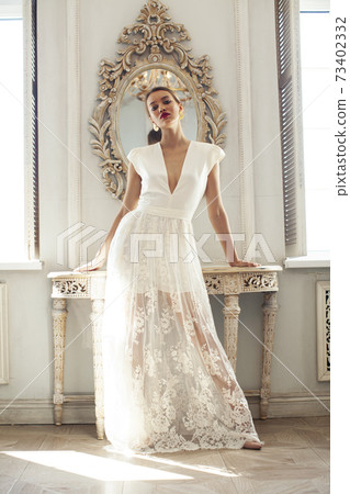 young pretty lady in white lace fashion style dress posing in rich interior of royal hotel room, luxury lifestyle people concept, bride on wedding day young pretty lady in white lace fashion style dress posing in rich interior of royal hotel room, luxury lifestyle people concept, bride on wedding day 73402332
