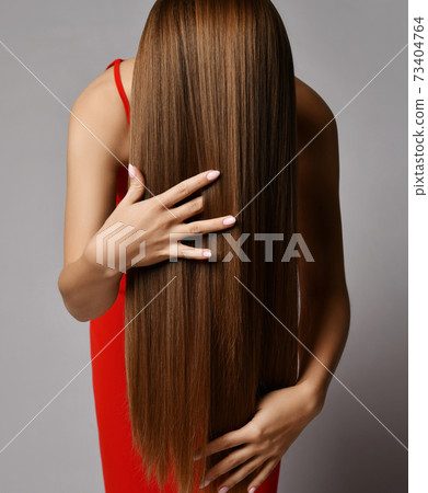 Woman in red dress has tilted haed forward and 73404764