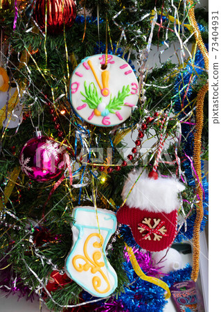Close-up of a Christmas tree with decorations made of baubles, snowflakes, tinsel, gingerbread and lights Close-up of a Christmas tree with decorations made of baubles, snowflakes, tinsel, gingerbread and lights 73404931