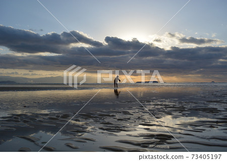 在退潮時走在海上的小男孩 73405197