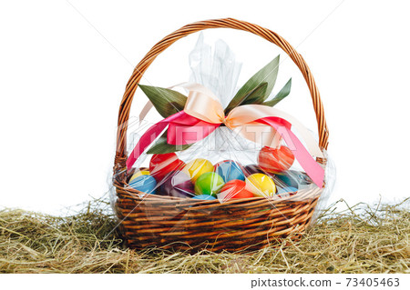 Easter gift basket with multicolor eggs, white background Easter gift basket with multicolor eggs, white background 73405463