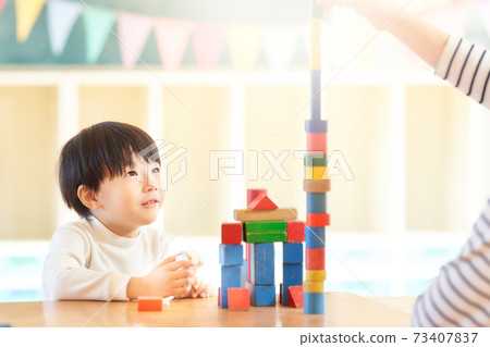 Little boy playing with blocks 73407837