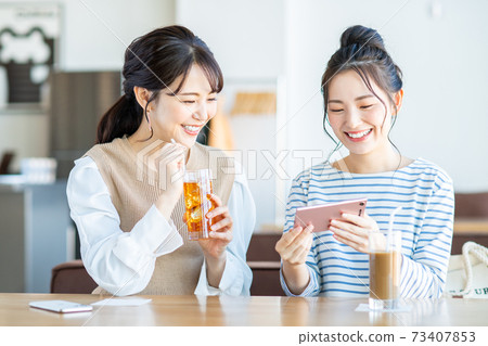 Young woman watching a video in a cafe Young woman watching a video in a cafe 73407853