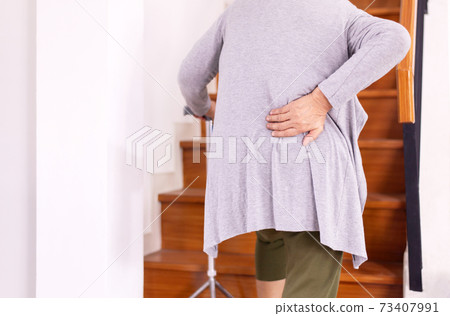 Senior older woman suffering from low-back lumbar pain while walking on stair at home,Low back pain lumbar backache 73407991