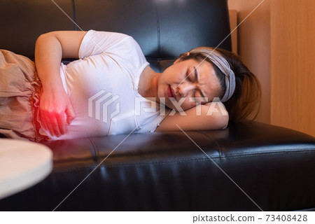 Depress woman having painful stomach ache,Female suffering from abdominal pain,Period cramps or premenstrual syndrome lying on sofa Depress woman having painful stomach ache,Female suffering from abdominal pain,Period cramps or premenstrual syndrome lying on sofa 73408428