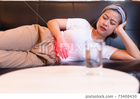Depress women having painful stomach ache,Female suffering from abdominal pain,Period cramps or premenstrual syndrome lying on sofa Depress women having painful stomach ache,Female suffering from abdominal pain,Period cramps or premenstrual syndrome lying on sofa 73408430