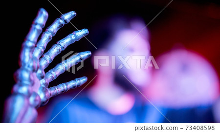 the hand of the skeleton in the foreground in the nightclub blurred man in the background the hand of the skeleton in the foreground in the nightclub blurred man in the background 73408598