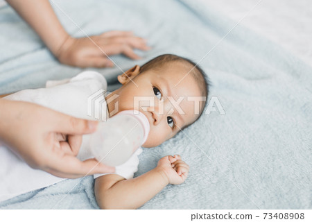 Little newborn baby boy sleep and drinking milk on a comfortable bed in the morning 73408908