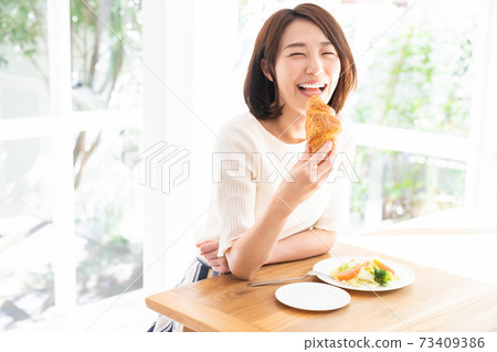 女人吃沙拉和麵包 73409386