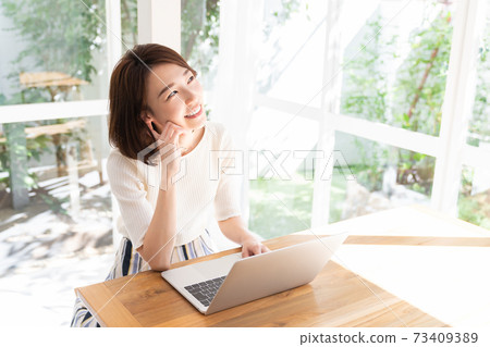 觀看一台便攜式計算機的婦女在屋子裡 觀看一台便攜式計算機的婦女在屋子裡 73409389