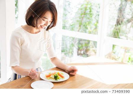 Woman eating salad Woman eating salad 73409390