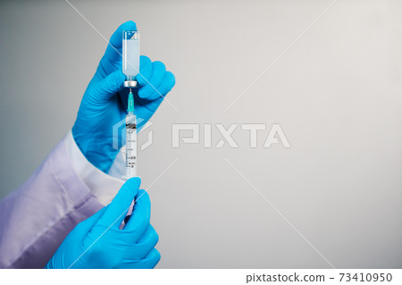 hand drawing vaccine bottle into syringe injection medicine 73410950