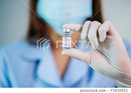 doctor holding Coronavirus (Covid-19) vaccine bottle for injection medicine 73410952