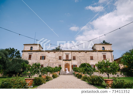 Wedding in Florence, Italy, in an old villa-winery. Wedding couple walks in the garden. Loving bride and groom. 73411352