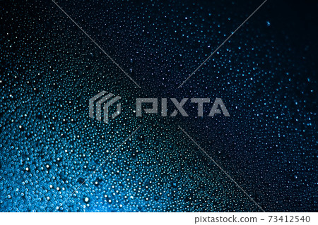 Raindrops on blue glass background close-up. Water drops blue texture. 73412540