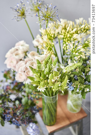 Set of white and blue flowers for Interior decorations. The work of the florist at a flower shop. Fresh cut flower. European floral shop. Delivery fresh cut flower Set of white and blue flowers for Interior decorations. The work of the florist at a flower shop. Fresh cut flower. European floral shop. Delivery fresh cut flower 73413697
