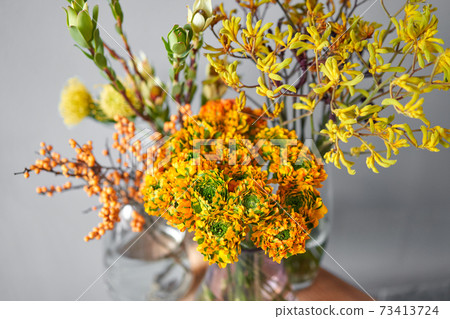 Set of yellow nd orange flowers for Interior decorations. The work of the florist at a flower shop. Fresh cut flower. European floral shop. Delivery fresh cut flower Set of yellow nd orange flowers for Interior decorations. The work of the florist at a flower shop. Fresh cut flower. European floral shop. Delivery fresh cut flower 73413724