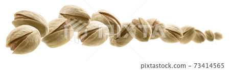Salted pistachios levitate on a white background 73414565