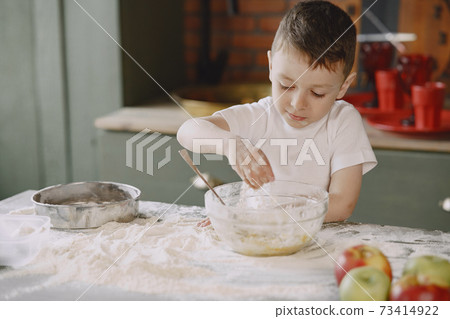 Little boy cook the dough for cookies Little boy cook the dough for cookies 73414922