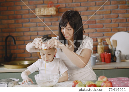 Family in a kitchen cook the dough for cookies Family in a kitchen cook the dough for cookies 73414931