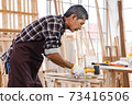 Asian senior man using wallet in woodwork at carpentry workshop. Concept senior people doing hobby after retirement. 73416506