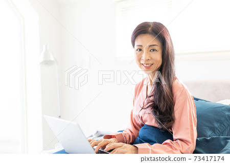 A woman who takes a computer at bed 73417174
