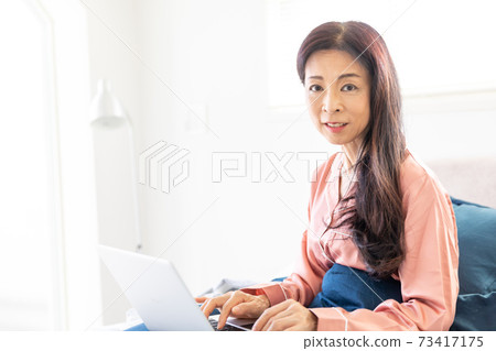 A woman who takes a computer at bed 73417175