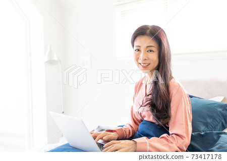 A woman who takes a computer at bed A woman who takes a computer at bed 73417178