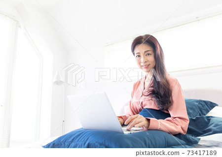 A woman who takes a computer at bed 73417189