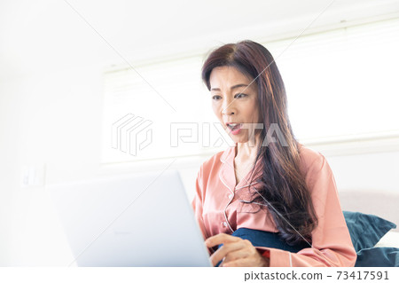 A woman who takes a computer at bed A woman who takes a computer at bed 73417591