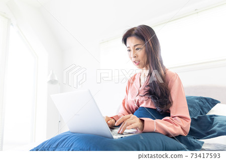 A woman who takes a computer at bed A woman who takes a computer at bed 73417593