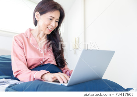 A woman who takes a computer at bed A woman who takes a computer at bed 73417605