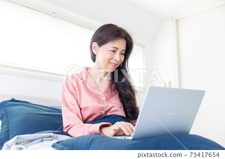 A woman who takes a computer at bed 73417654