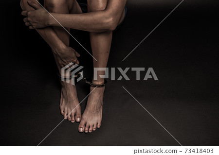 woman with handcuff in a black background woman with handcuff in a black background 73418403