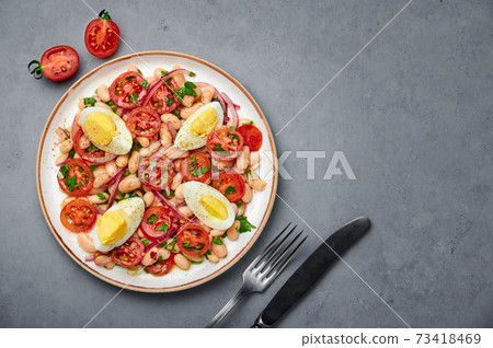 A Piyaz salad on white plate on gray concrete table top. Turkish cuisine vegetarian dish 73418469