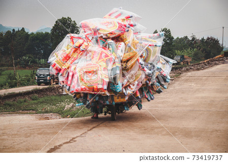 Vietnamese motorbike overloaded with cargo, shows the local culture and daily life in the countrysides of Vietnam 73419737