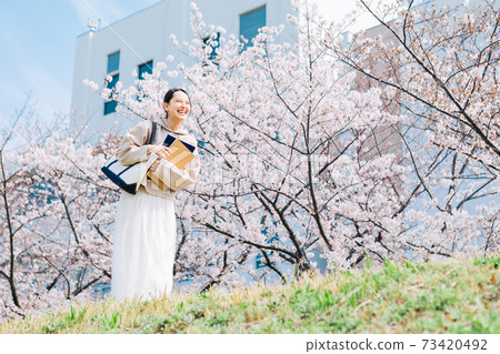 Cherry blossom and smiling university student 73420492
