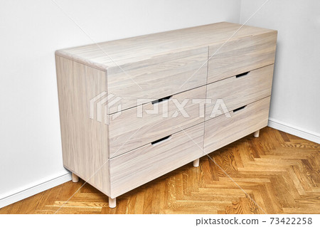 Chest of drawers with bleached solid oak stands on parquet floor 73422258