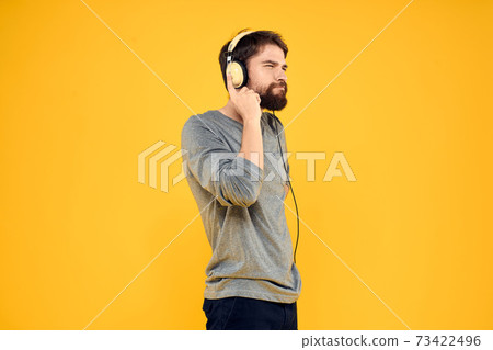 Man with headphones music lifestyle lifestyle technology yellow background 73422496