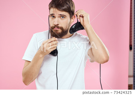 Man with two joysticks in hands fun game technology lifestyle pink background Man with two joysticks in hands fun game technology lifestyle pink background 73424325