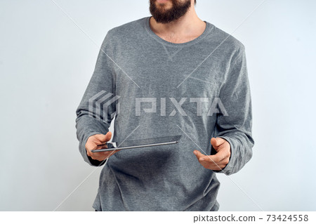 Man with tablet in hands technology lifestyle internet communication work light background cropped view Man with tablet in hands technology lifestyle internet communication work light background cropped view 73424558