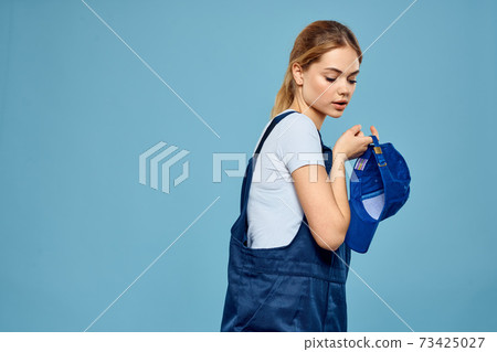 Woman in work uniform blue cap carriage delivery service courier blue background Woman in work uniform blue cap carriage delivery service courier blue background 73425027