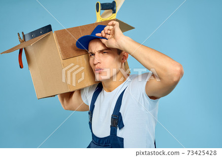 working man in uniform box with tools loader delivery blue background working man in uniform box with tools loader delivery blue background 73425428
