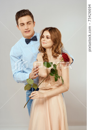 Cheerful young couple romance embrace relationship red rose lifestyle light background 73426694