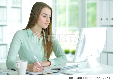 Portrait of a businesswoman working in office Portrait of a businesswoman working in office 73427763