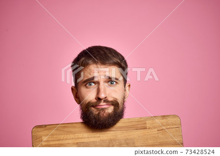 guy holding kitchen board and spatula in hand on pink background cropped view guy holding kitchen board and spatula in hand on pink background cropped view 73428524